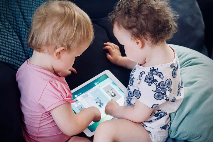 zwei Kleinkinder nutzen ein Tablet - eine typische Situation bei einem Usability-Test mit Kindern
