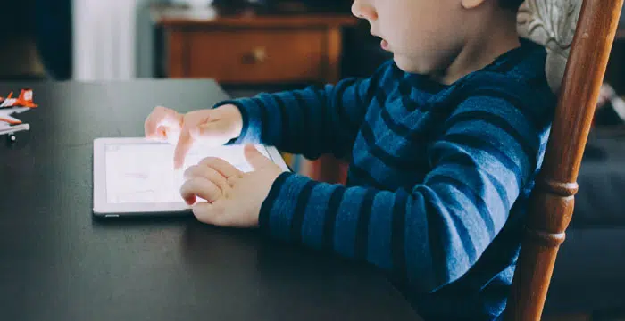 Usability-Test mit Kind: Junge nutzt Tablet und schaut konzentriert
